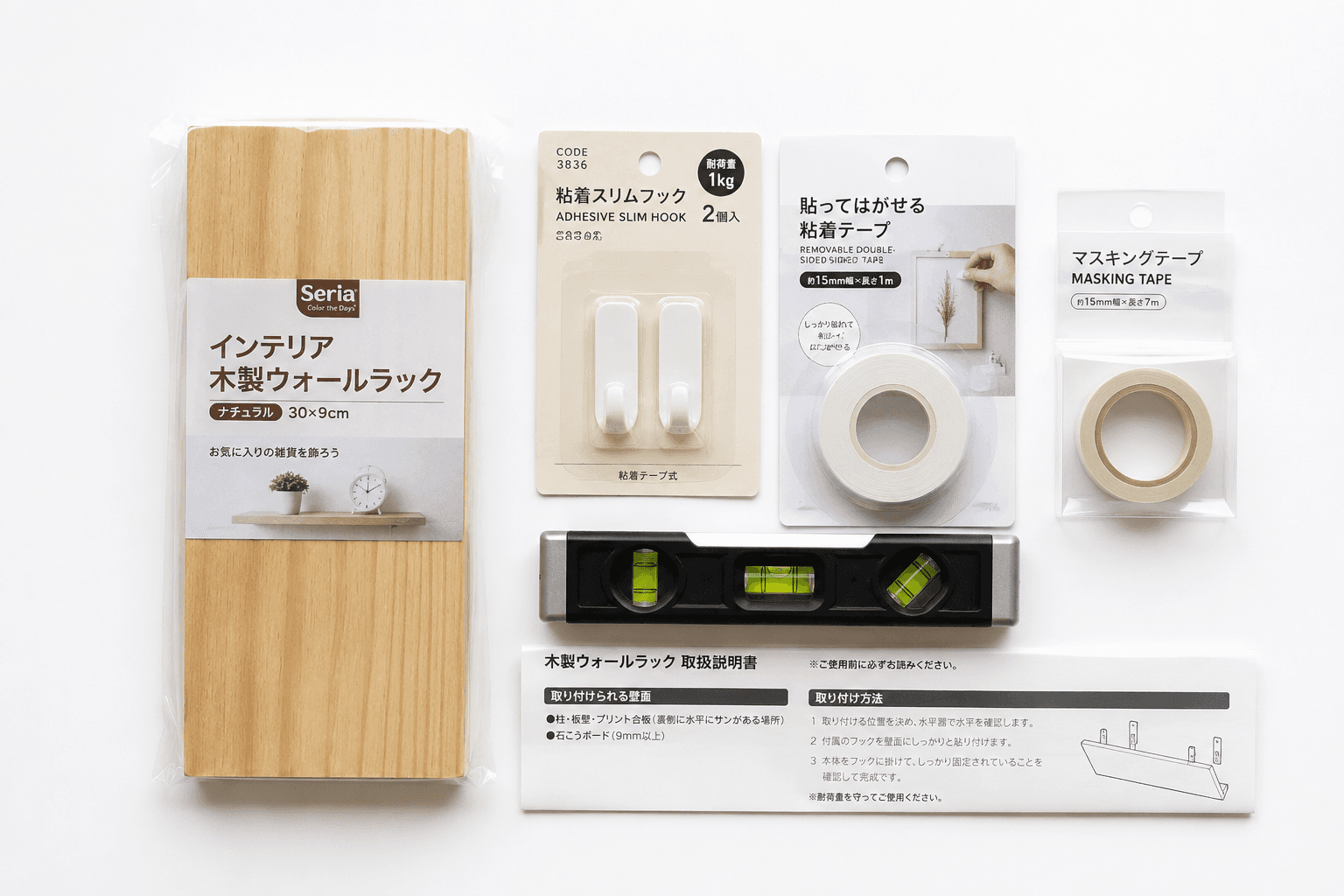 壁掛け棚DIYに使う100均アイテムの俯瞰。木製棚板・剥がせる両面テープ・水準器・マスキングテープが白背景に整列